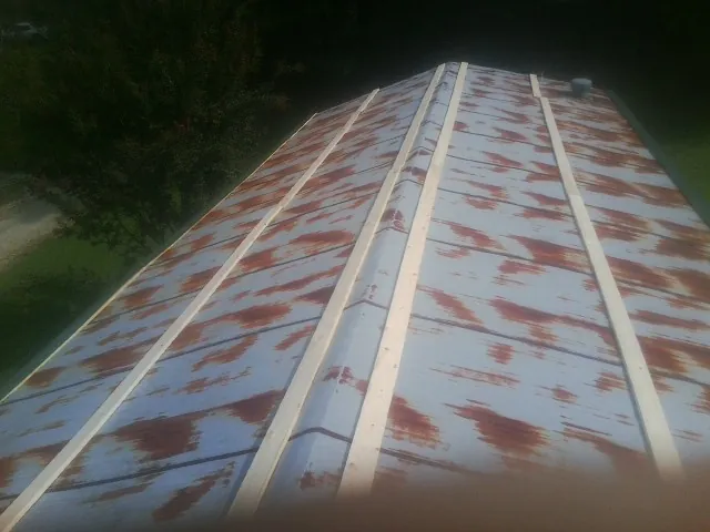 Rusted metal roof panels with new wood purlins before replacement — Storm Damage Roof Repair in Cushing by Roofing Brothers