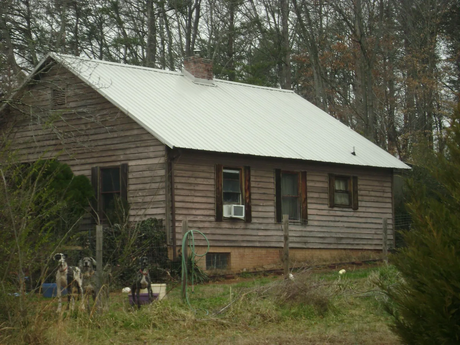 White metal roof on an old wood sided farmhouse, from a Metal Roof Installation job in Cushing